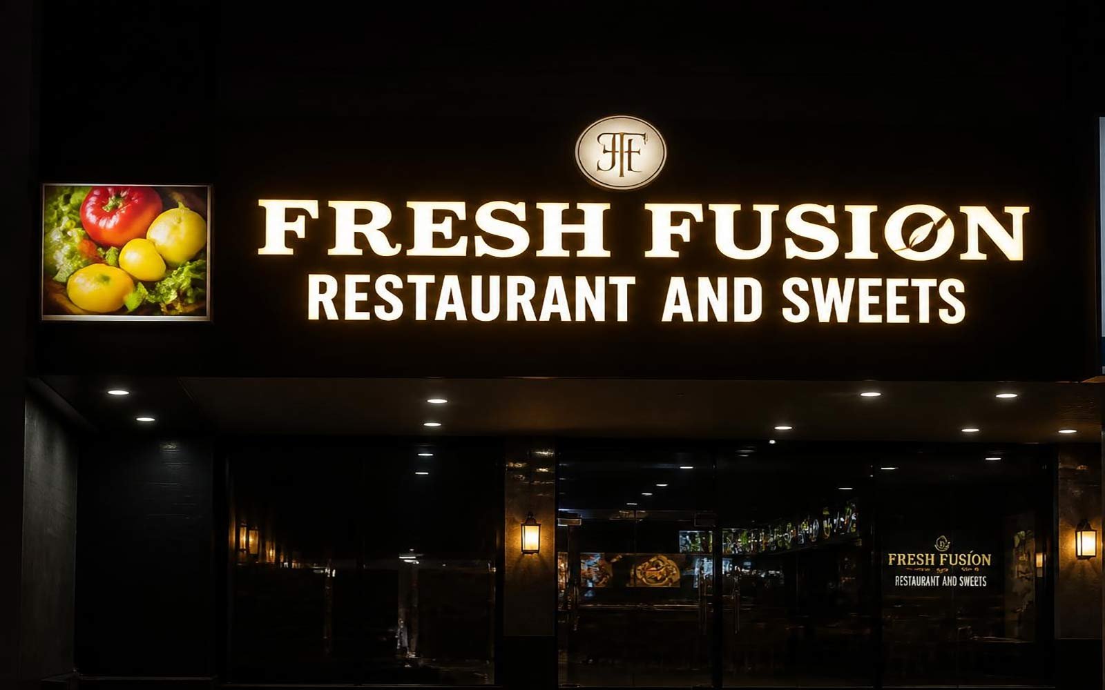 Warm illuminated Fresh Fusion Restaurant and Sweets fascia at night