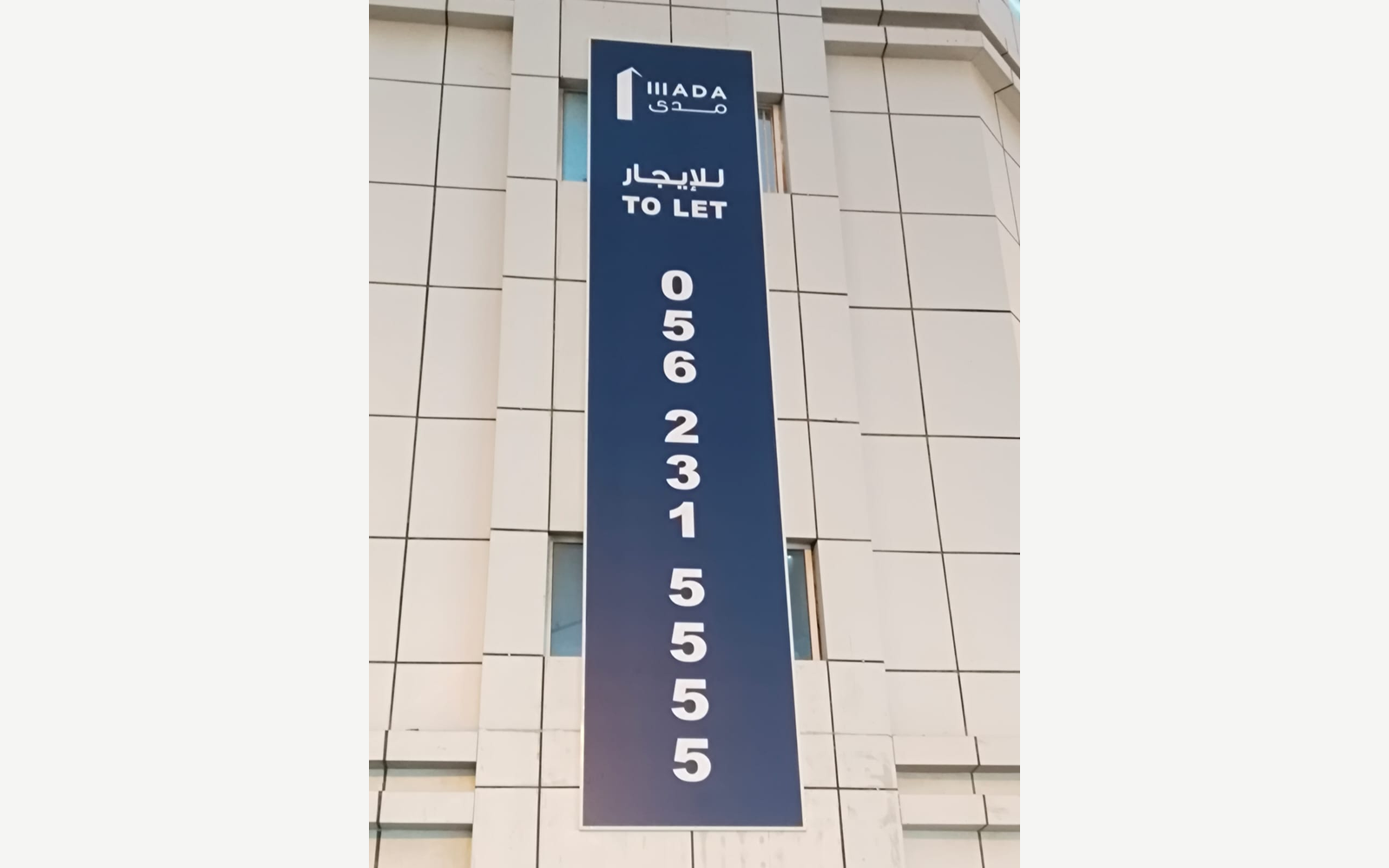 بانر رأسي للإيجار بالعربية والإنجليزية على واجهة مبنى