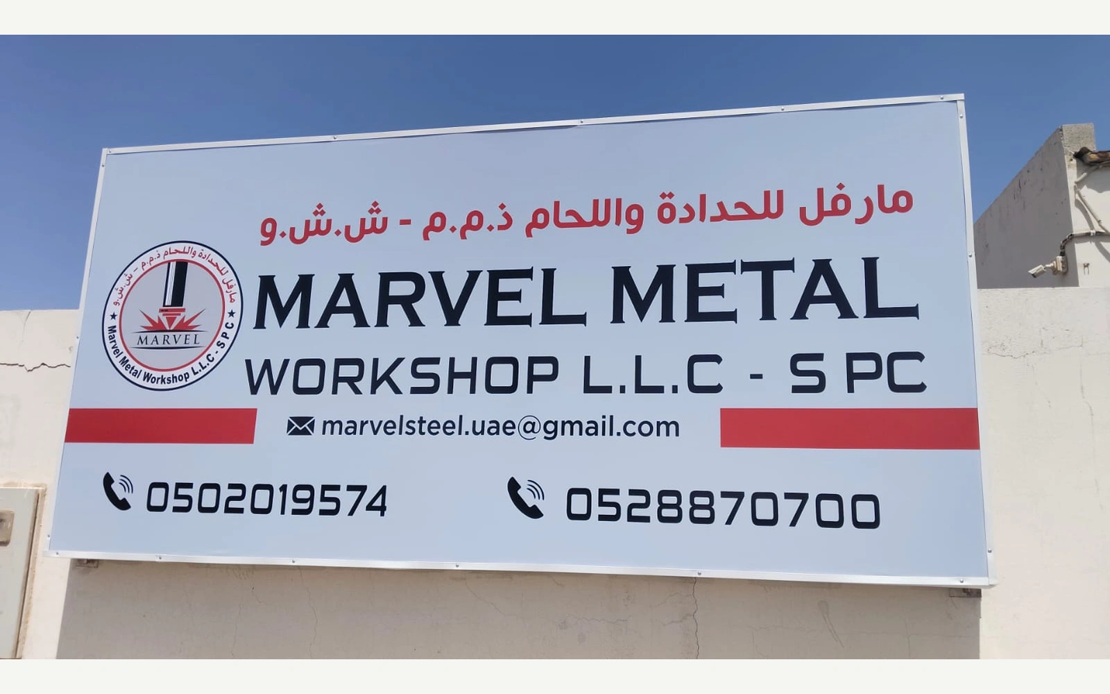 لوحة فلكس بالعربية والإنجليزية لمارفل ميتال على جدار خارجي