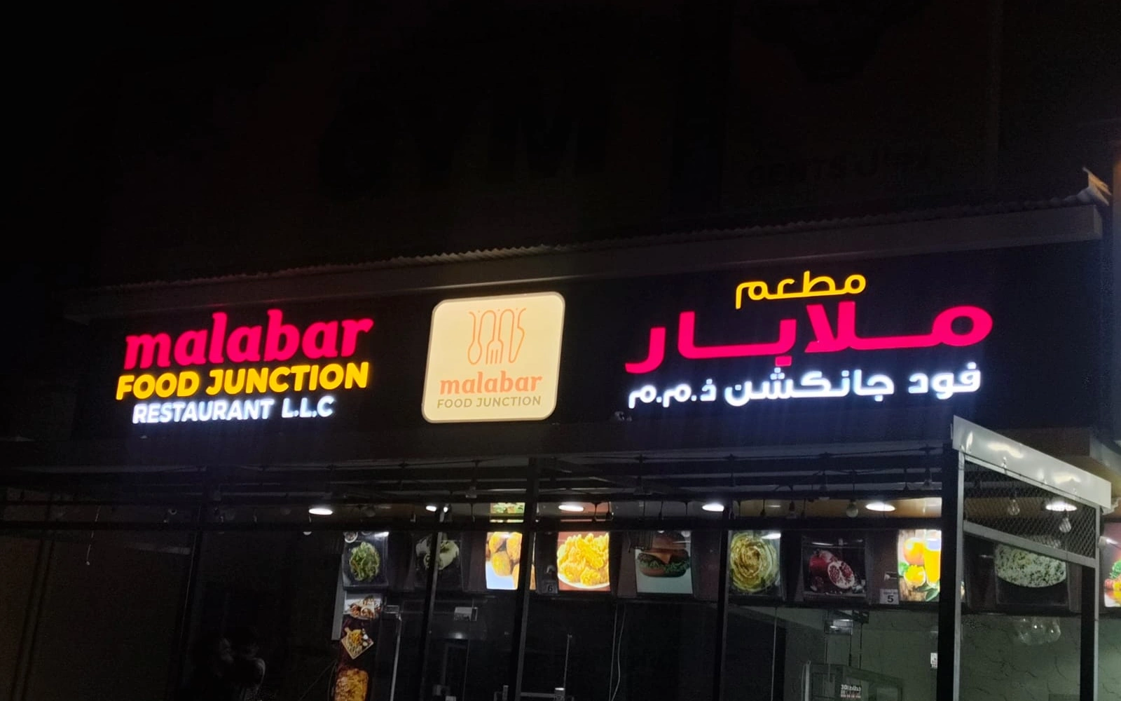 Bilingual illuminated Malabar Food Junction restaurant fascia at night